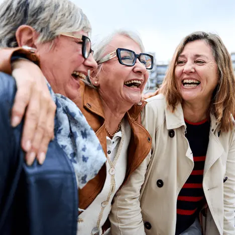 Drei ältere Freundinnen lachen miteinander